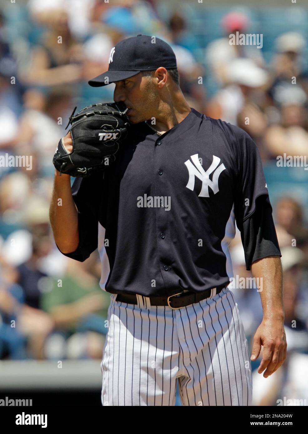 New York Yankees pitcher Andy Pettitte holds his glove to his face as he  sizes up a hitter in the sixth inning of the Yankees 8-3 victory over the  New York Mets