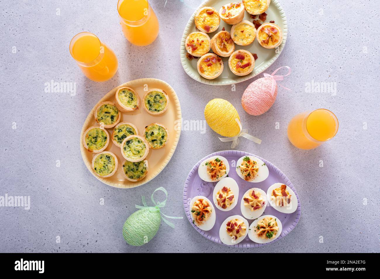 Deviled eggs and mini quiches appetizers for easter brunch with mimosa