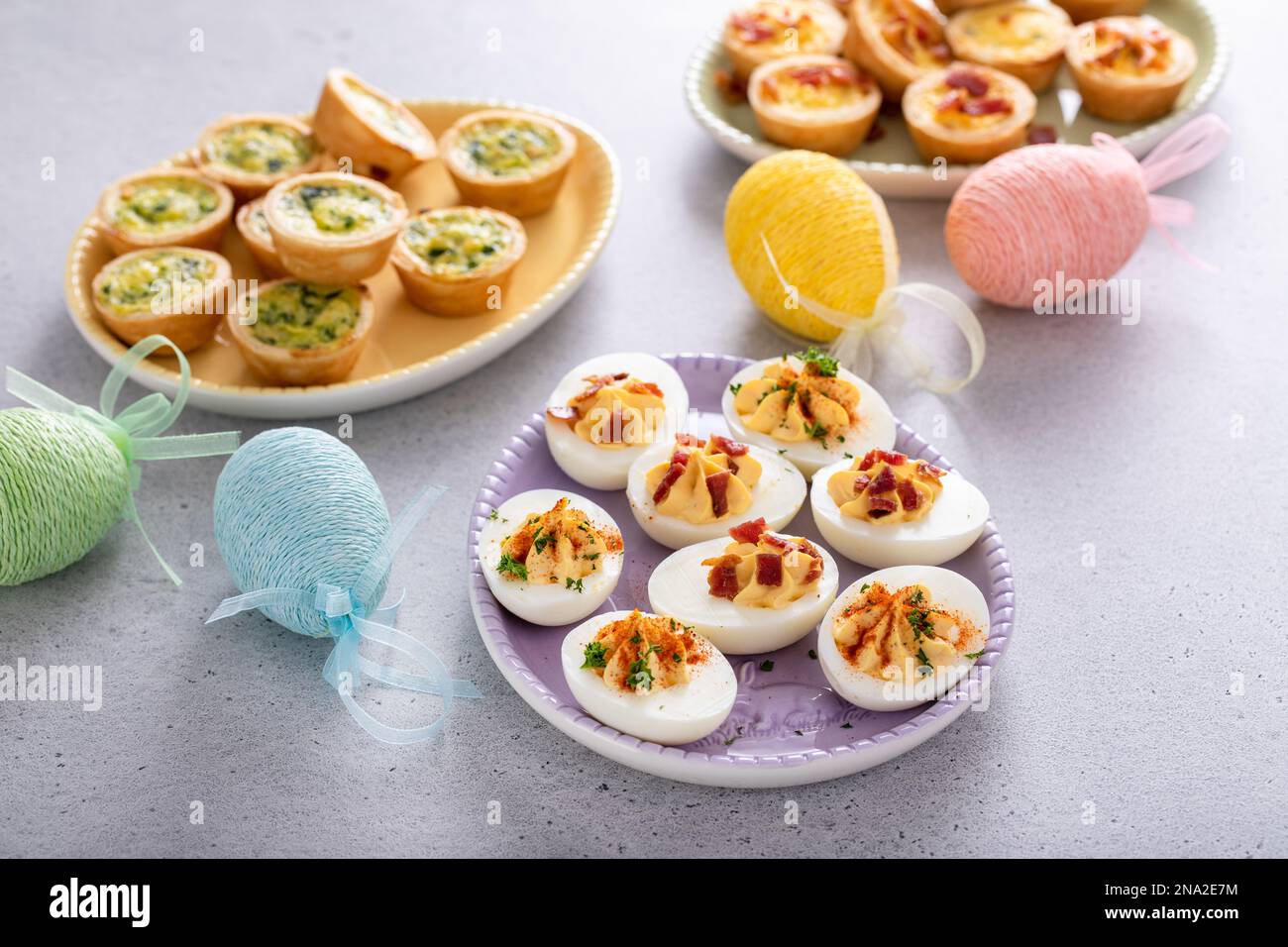 Deviled eggs and mini quiches appetizers for easter brunch stock photo