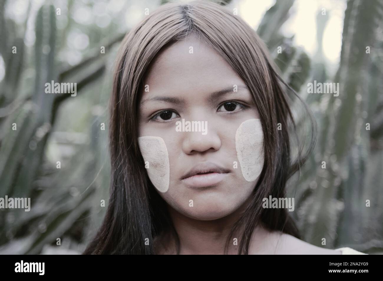 Portrait of a young woman from Myanmar with white face paint on her cheeks; Bagan, Myanmar Stock Photo