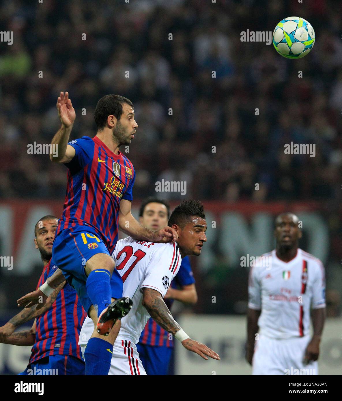 Barcelona midfielder Sergio Busquets heads the ball over AC Milan  midfielder Kevin Prince Boateng, of Ghana, during a Champions League first  leg quarterfinals soccer match, between AC Milan and Barcelona, at the