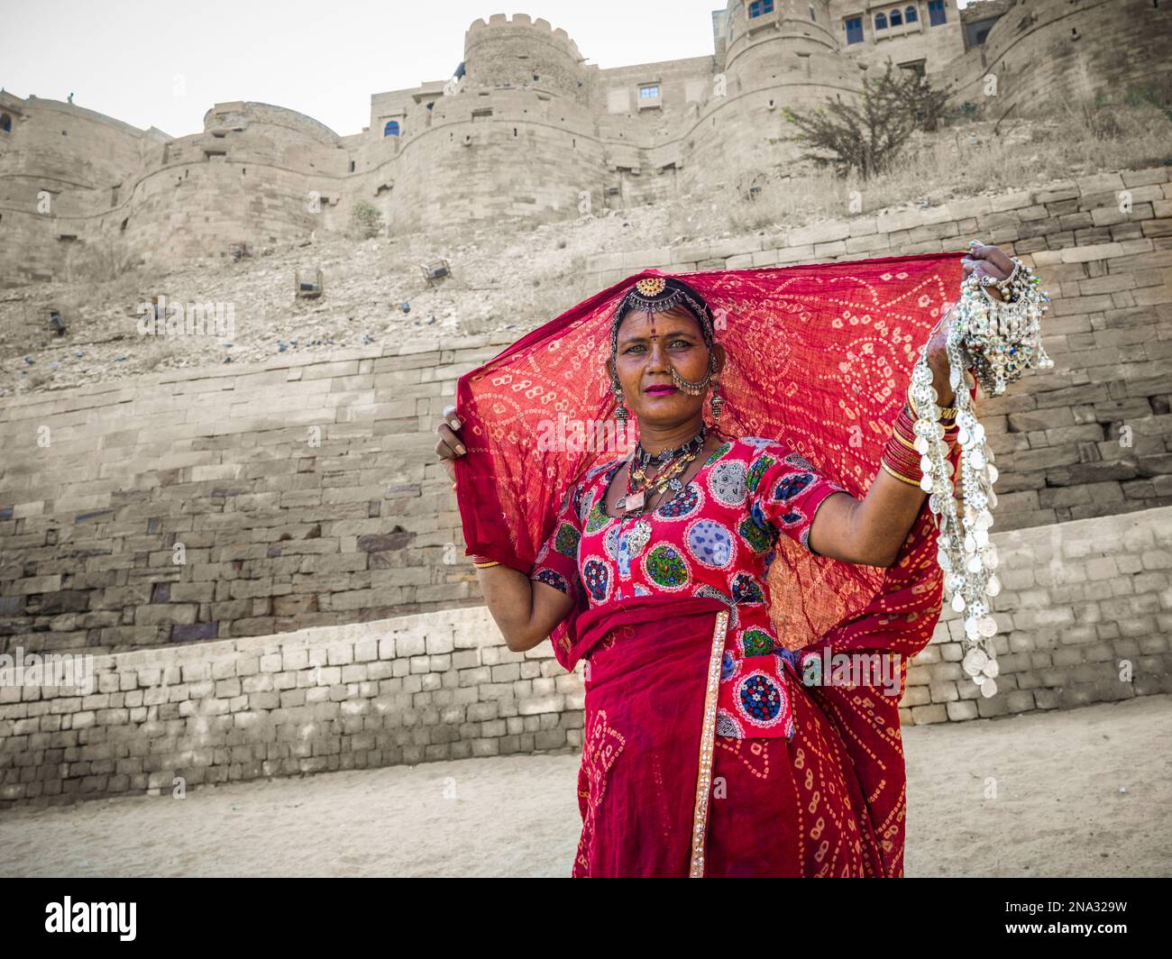 A woman in colourful traditional Indian clothing selling jewelry, Jaisalmer Fort; Jaisalmer, Rajasthan, India Stock Photo