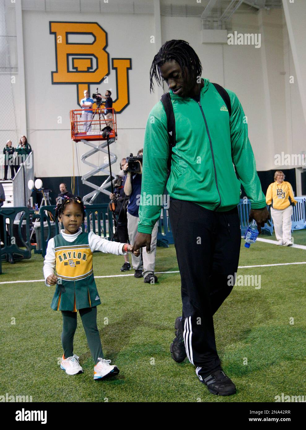 Baylor quarterback Robert Griffin III stands on the stage holding