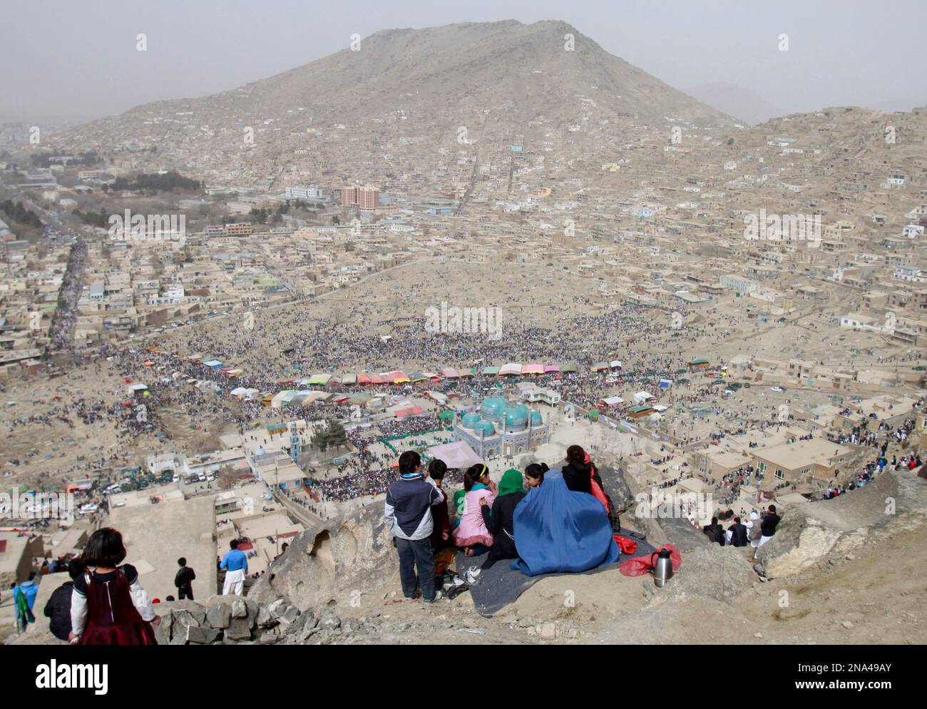 Afghans gather on a hillside to watch the raising of the holy mace