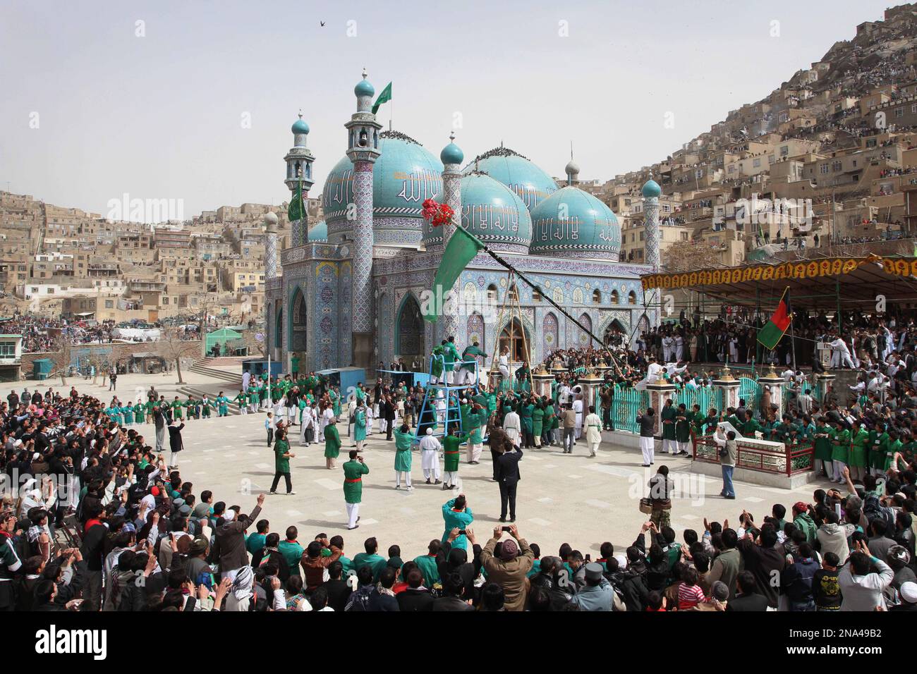 Afghan men raise the holy mace during a celebration of the Persian New