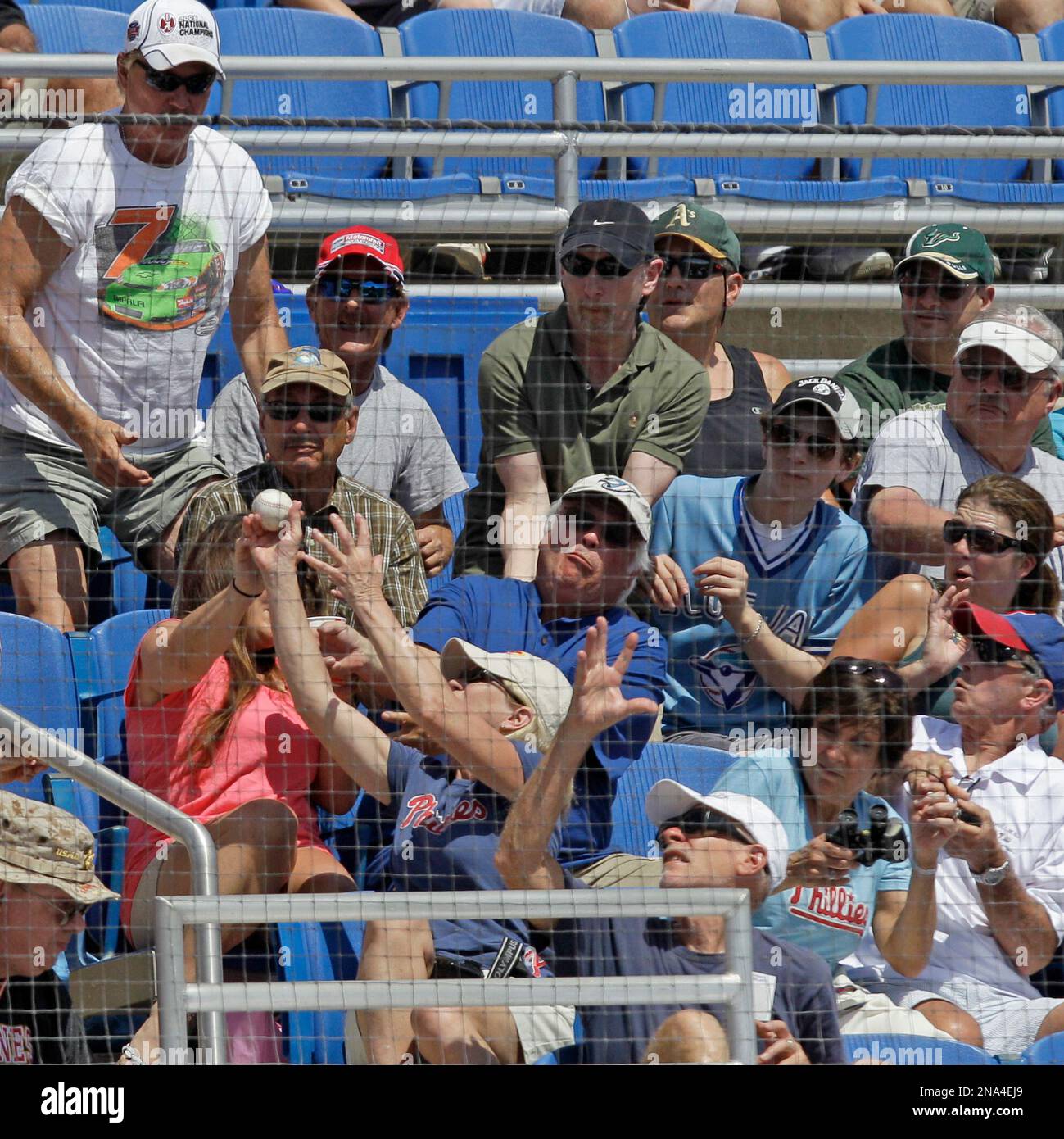 Baseball fans go after a foul ball hit into the stands during a spring