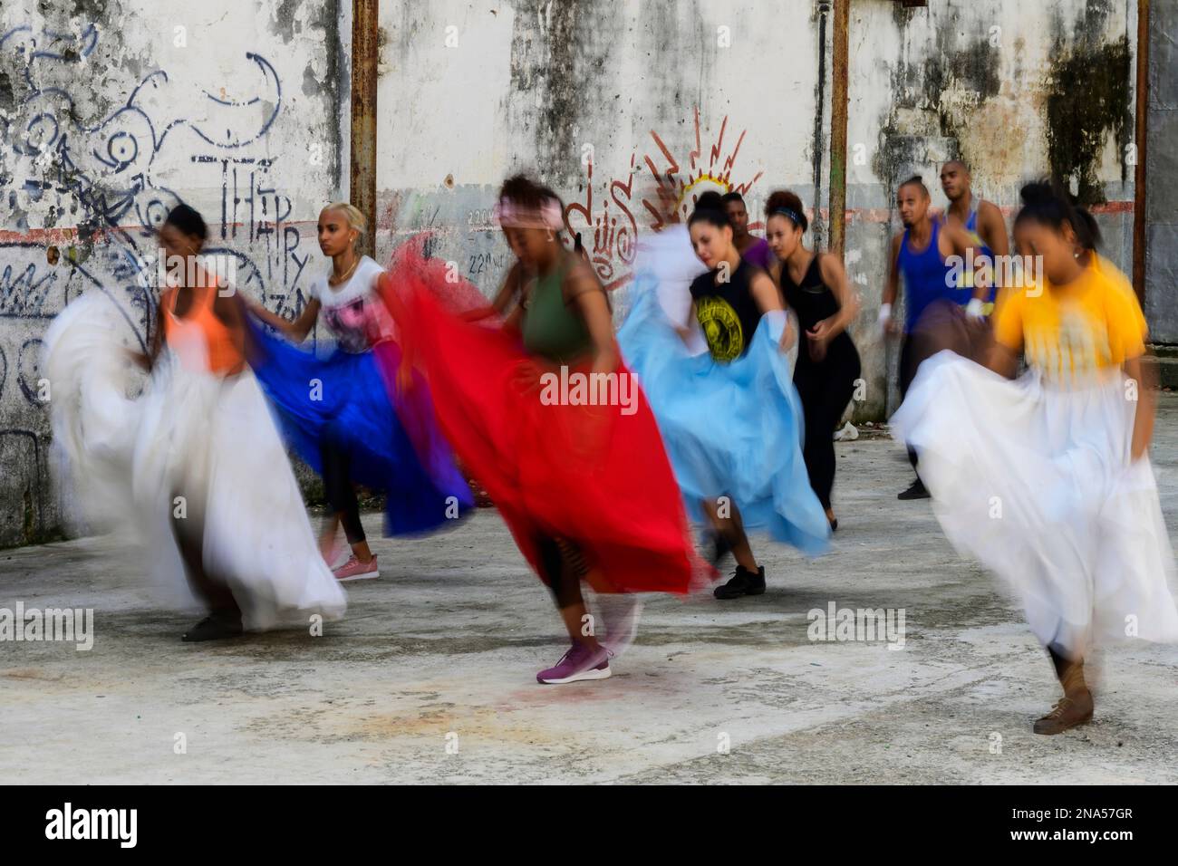 Young Cuban women dancing in an old concrete building with graffiti on the walls; Havana, Cuba Stock Photo
