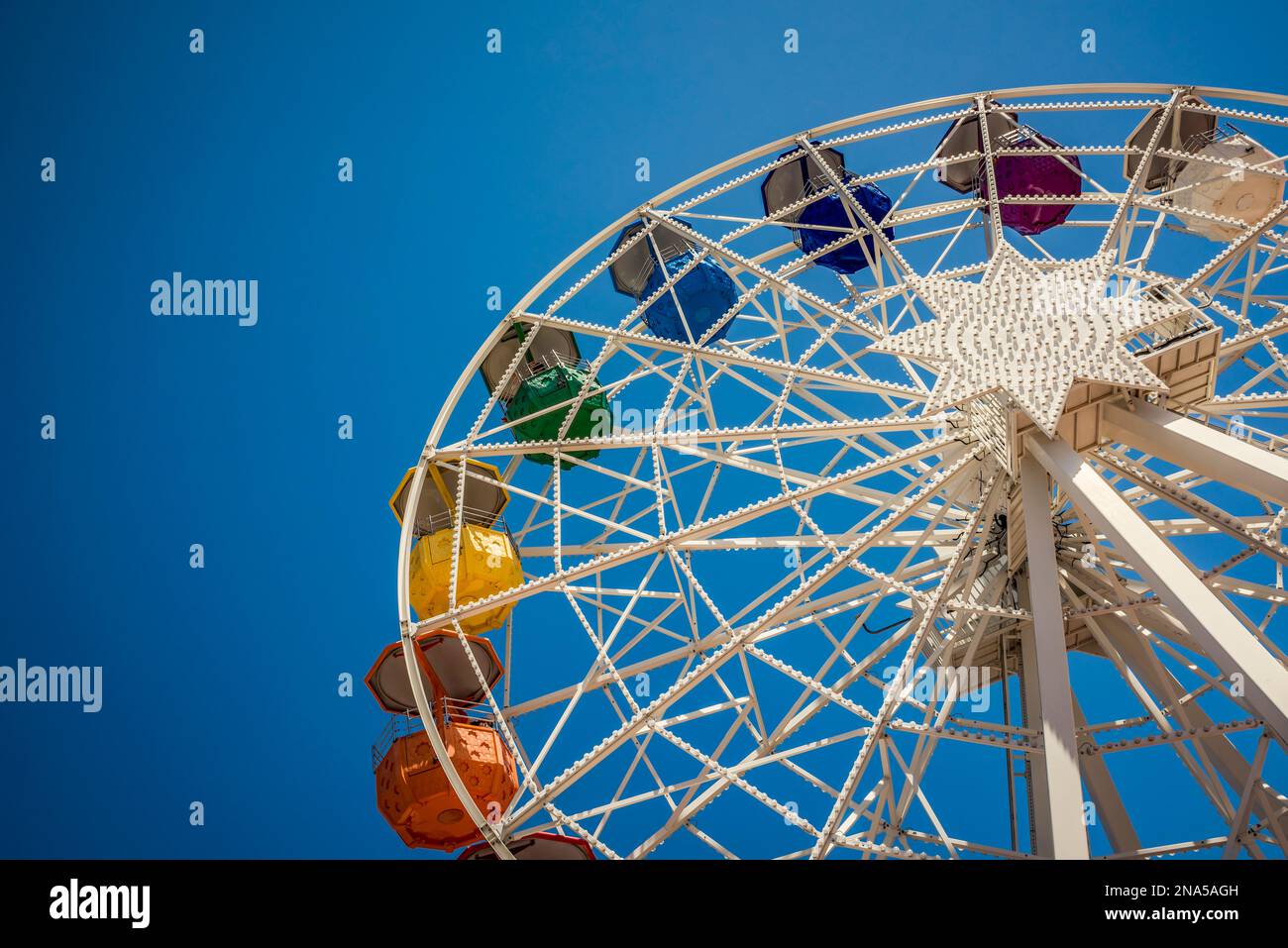 Colourful ferris wheel against a blue sky at the Tibidabo Amusement Park; Barcelona, Catalonia, Spain Stock Photo