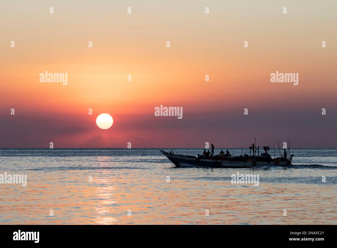 Boat on the Indian Ocean at sunset; Zanzibar City, Unguja Island, Zanzibar, Tanzania Stock Photo