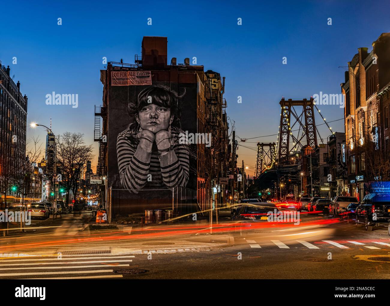 Williamsburg Bridge and the Mona Lisa of Williamsburg at dusk; New York City, New York, United States of America Stock Photo