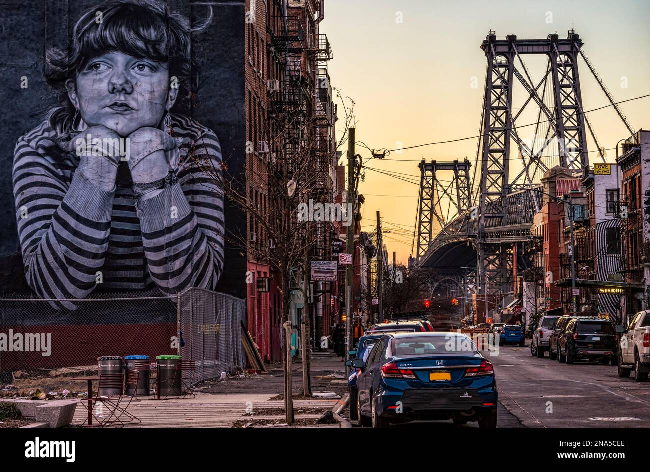 Williamsburg Bridge and the Mona Lisa of Williamsburg at dusk; New York City, New York, United States of America Stock Photo