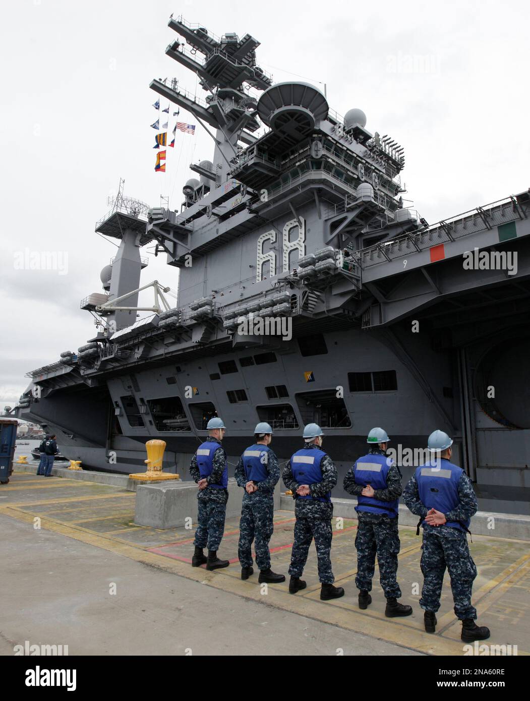 U.S. Navy sailors stand at attention as the USS Nimitz aircraft carrier