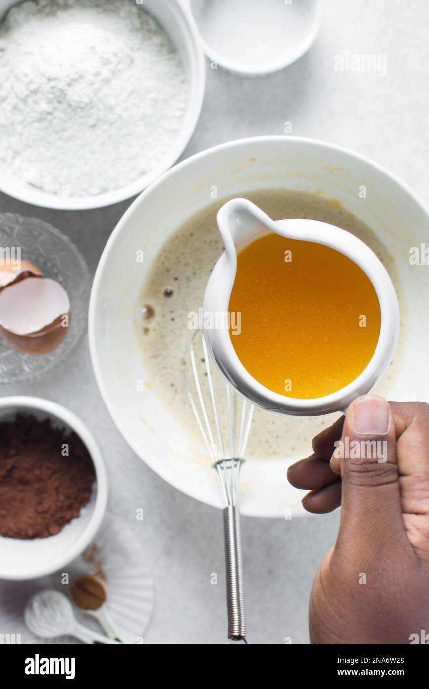 Pouring melted butter into a white mixing bowl Stock Photo Alamy