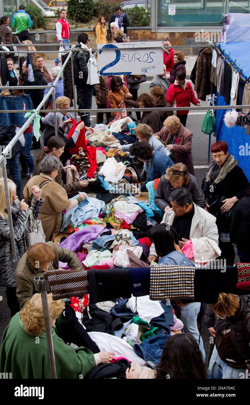 People look for bargains in a street market in Madrid Sunday March 4, 2012.  Spain, a recession-ridden country, will miss its deficit goal for this  year, risking sanctions from the European Union