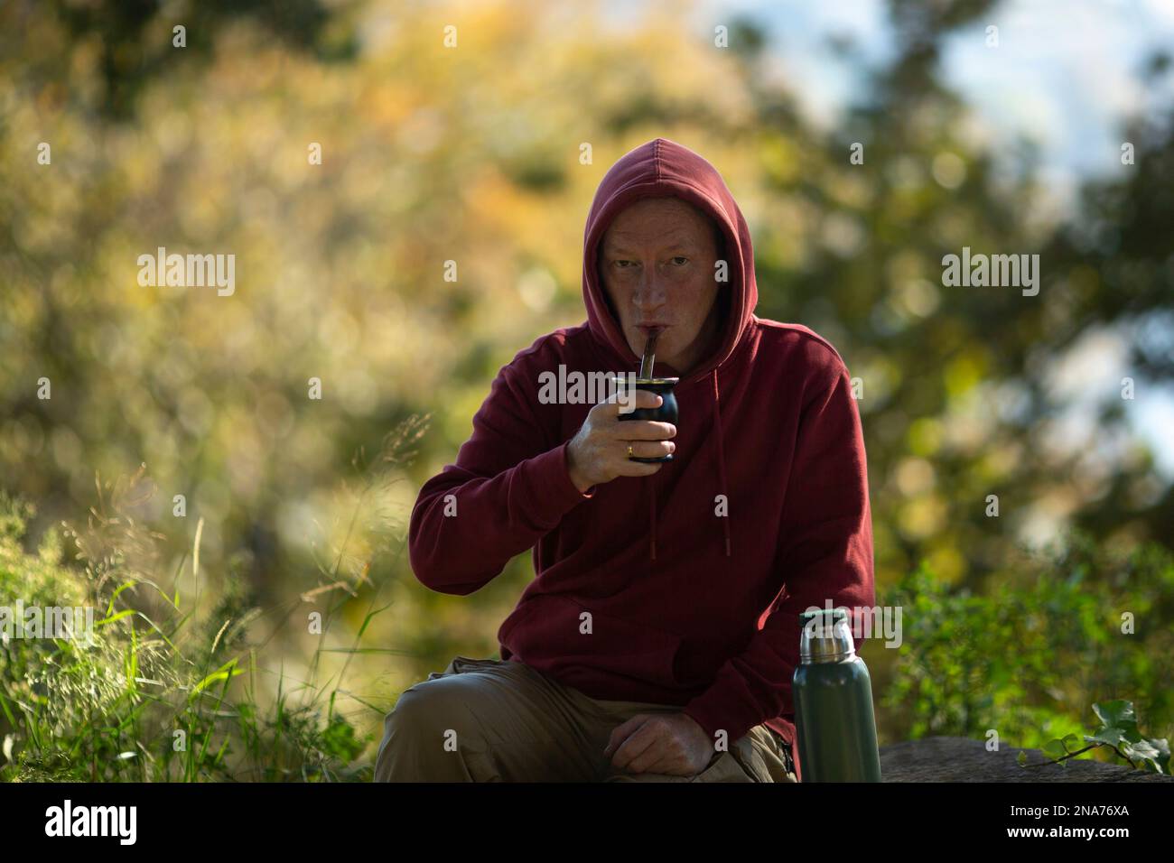 A man drinks mate from a mate mug in the park. Stock Photo