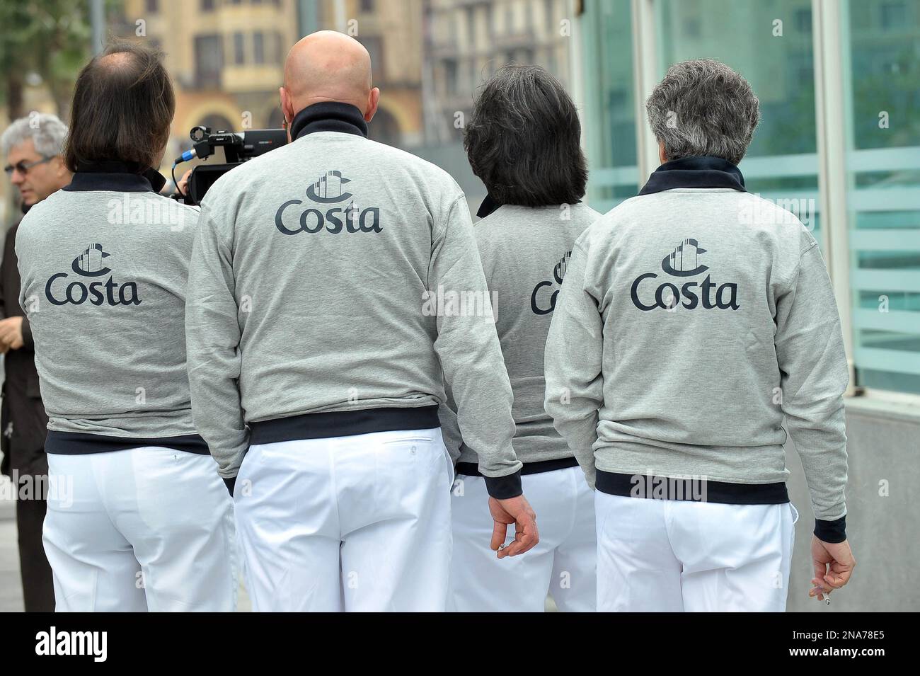 Costa crewmen stand as the renewed cruise ship Costa Neo Romantica