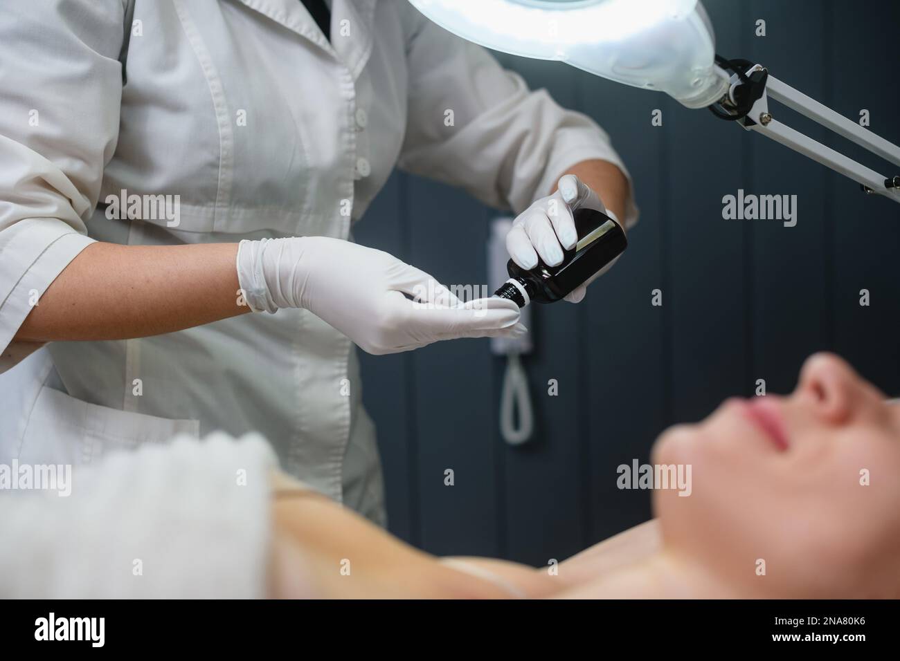 Cosmetologist beautician dermatologist apply lidocaine, painkiller gel