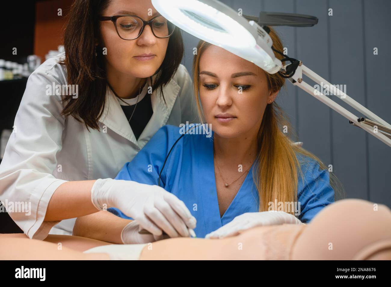 Beautician teach intern how to make electrolysis hair removal in spa