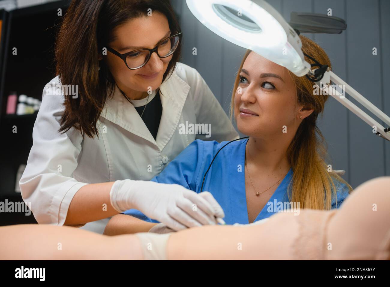 Beautician teach intern how to make electrolysis hair removal in spa