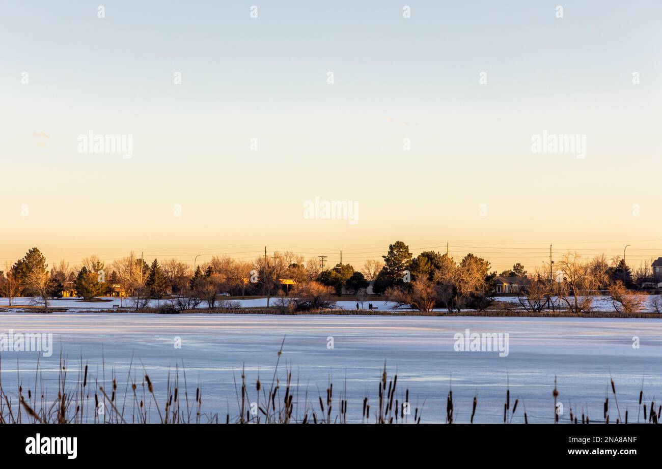 Kendrick Lake Park in Denver, Colorado. Iced lake at sunset with houses