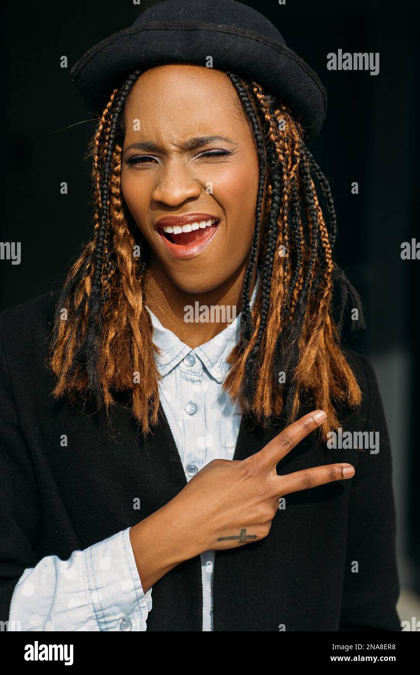 Victory gesture. Joyful young black lady. Stock Photo