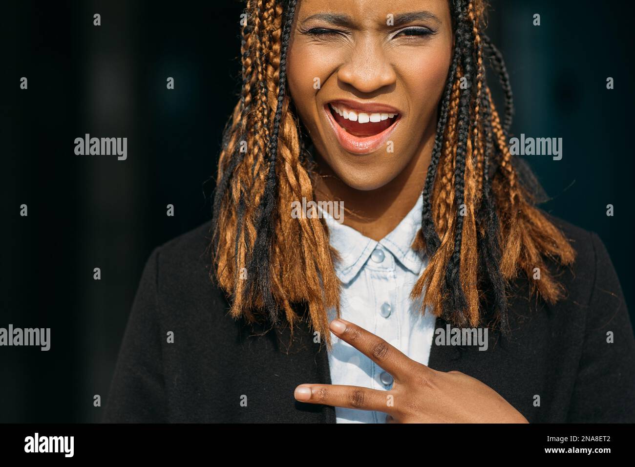Joyful young black lady. Victory gesture Stock Photo