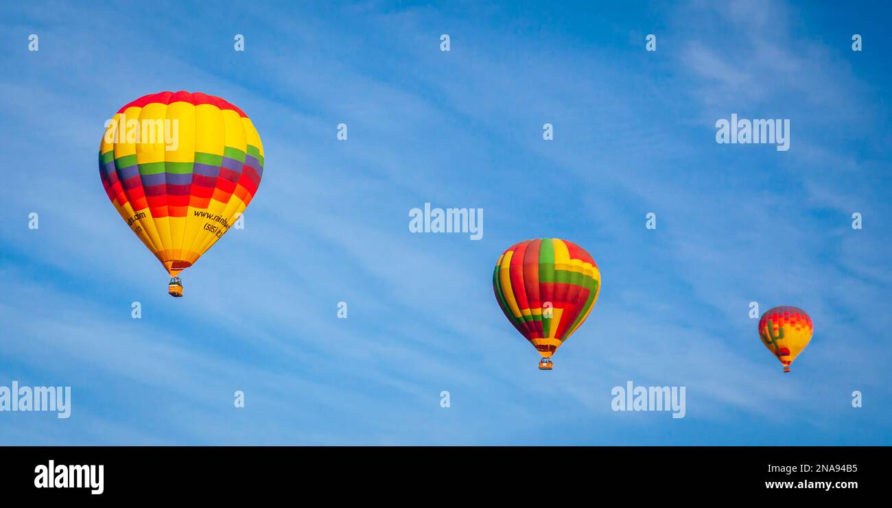 Three vibrant coloured hotair balloons in the air; Phoenix, Arizona