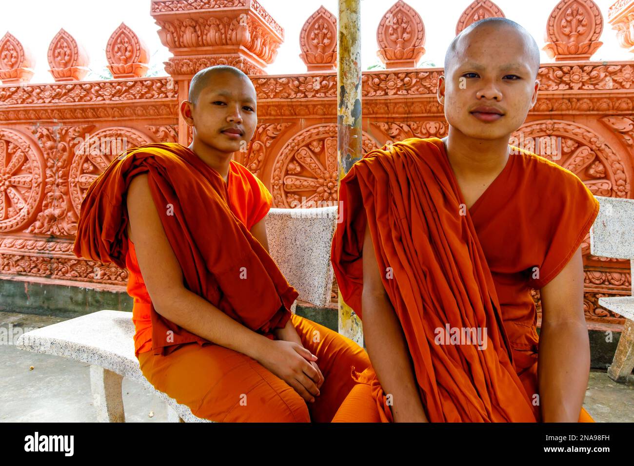 Two young monks in saffron robes in Buddhist monastery, Sihanoukville, Cambodia; Krong Preah Sihanouk, Sihanoukville, Cambodia Stock Photo