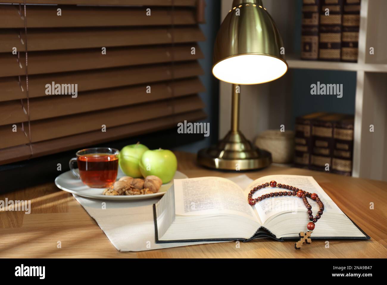 Holy Bible with prayer beads and snacks on wooden table indoors. Great ...