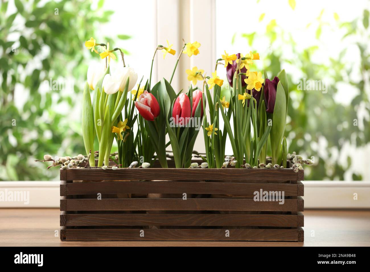 Beautiful spring flowers in wooden crate on window sill Stock Photo - Alamy
