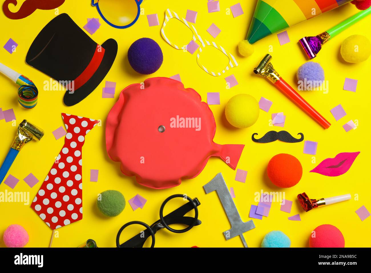Different clown's accessories on yellow background, flat lay Stock Photo