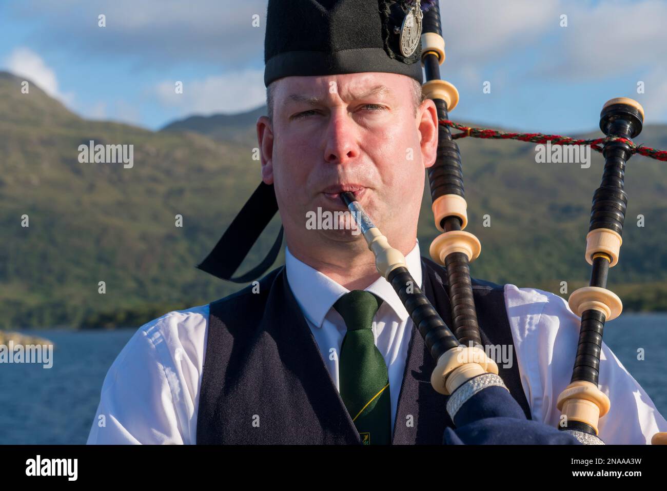 A Scottish bagpiper plays bagpipes in Kyle of Lochalsh, Scotland; Kyle