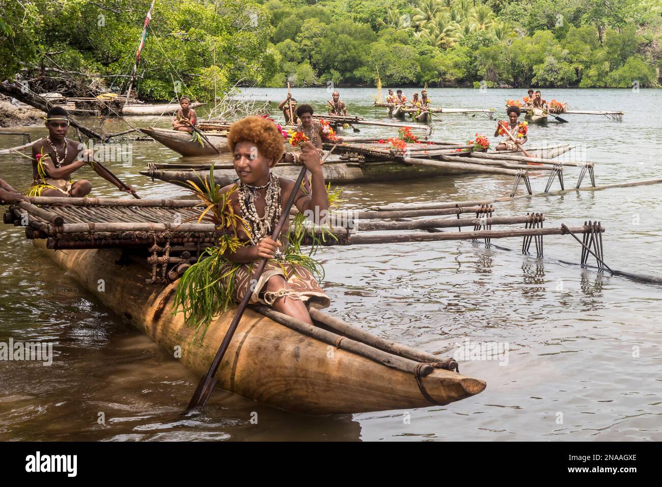 Melanesian woman in traditional dress with tapa bark cloth dress of Natade Village in outrigger canoes at the entrance to the Tufi Fjords of Cape Nels Stock Photo