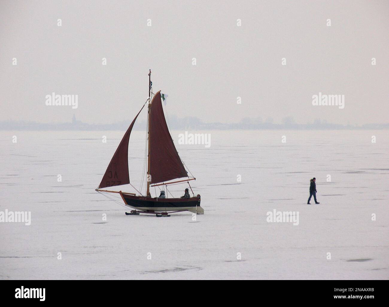 A traditional Dutch 19th century ice yacht sails along the ice on the ...