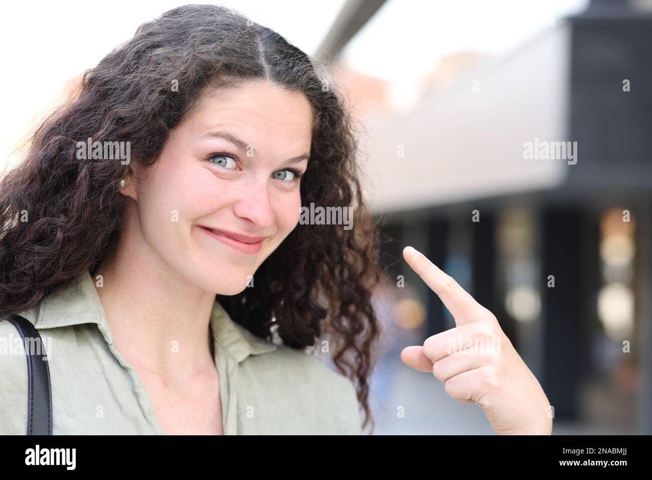 Woman pointing herself in the street Stock Photo