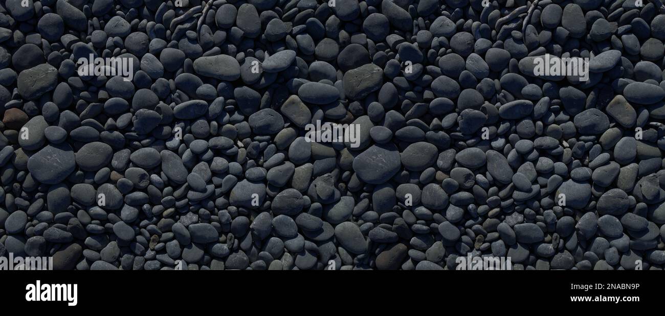 Black pebbles on a beach. background texture. Banner wallpaper Stock Photo