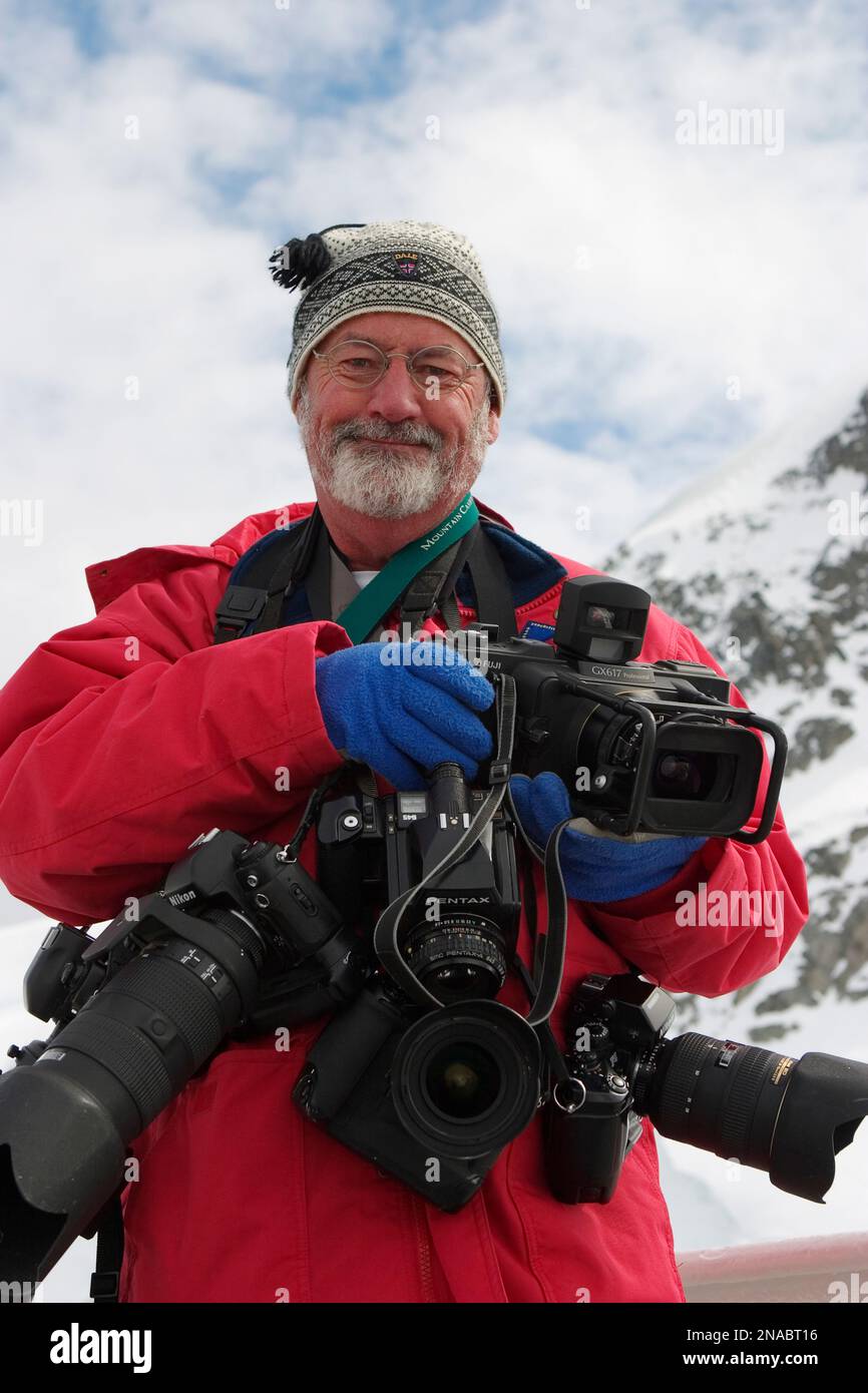 Portrait of a photographer and his equipment in winter clothing. Stock Photo
