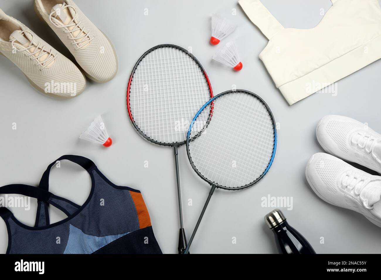 Flat lay composition with rackets and shuttlecocks on light grey ...