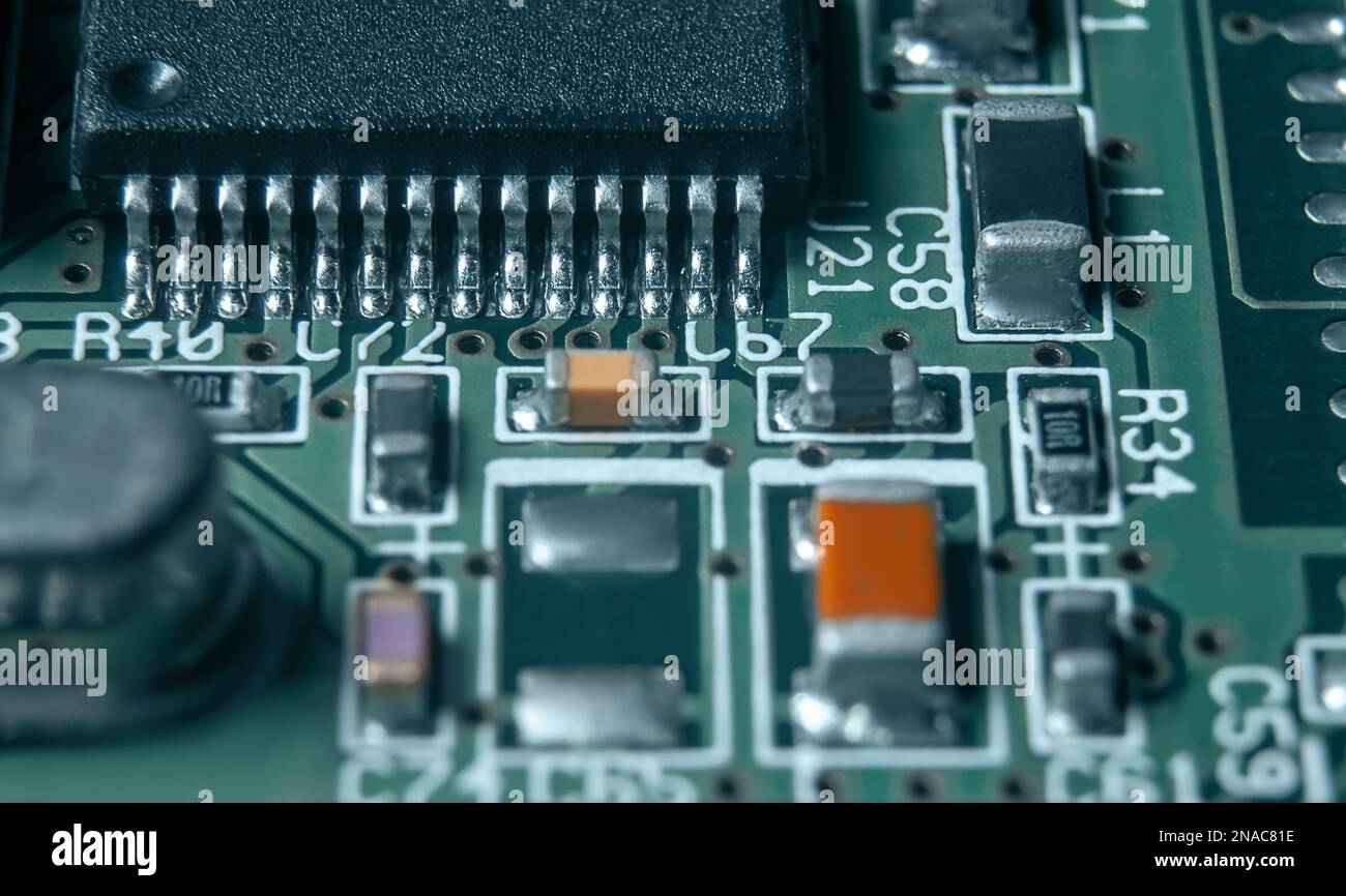 Closeup of Printed Circuit Board with processor, integrated circuits and many other surface mounted passive electrical components. Stock Photo