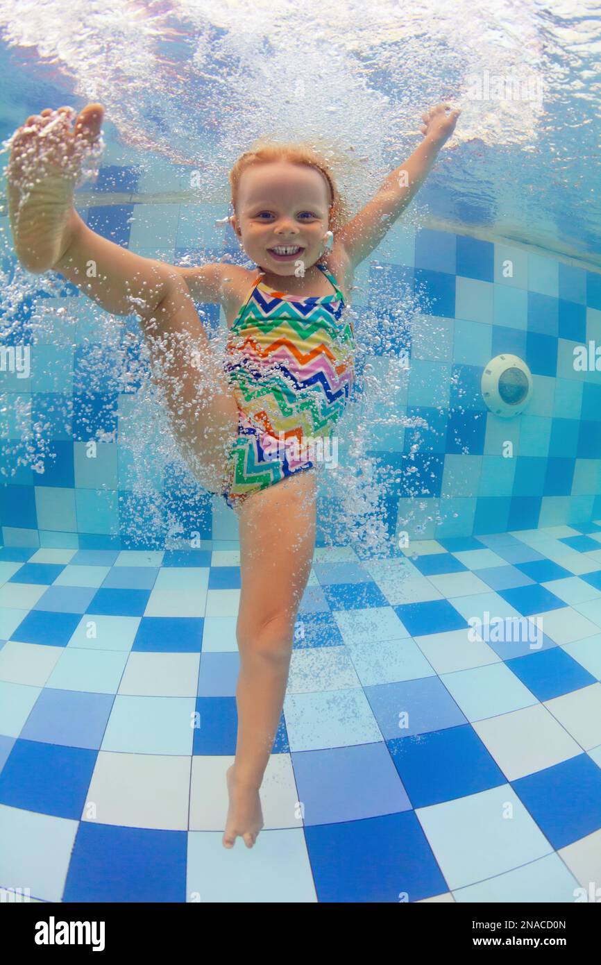 Happy family have fun in swimming pool. Funny child swim, dive in pool