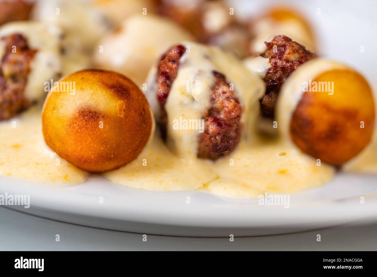 Baked meatball from beef, croquette in cheese lemon sauce on white plate, closeup. Stock Photo