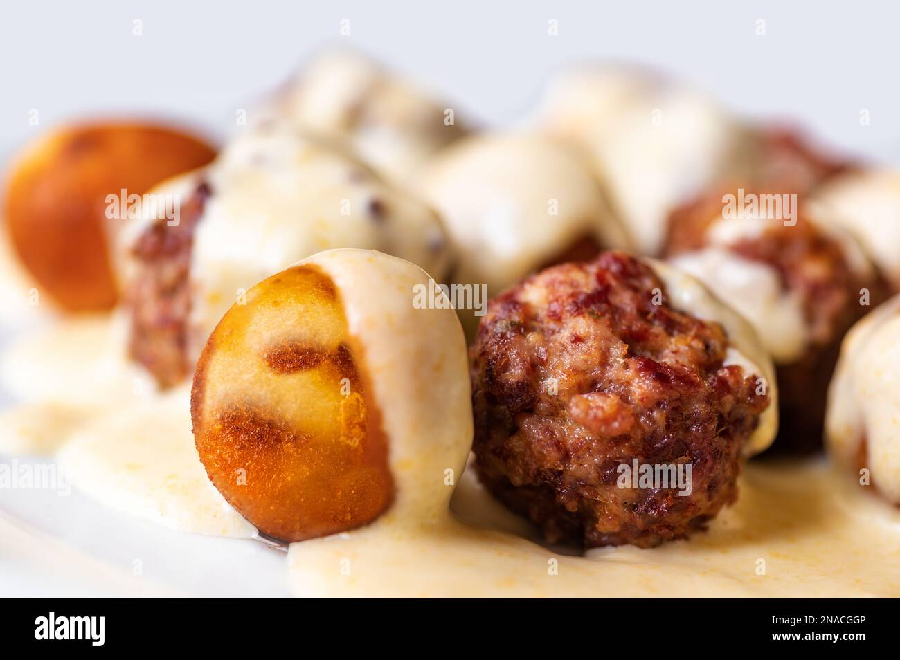 Baked meatball from beef, croquette in lemon cheese sauce, closeup. Stock Photo