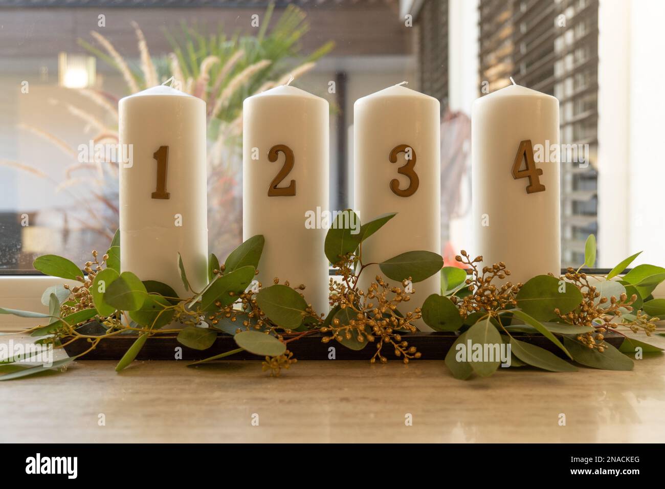 The three white candles with numbers on a wooden table Stock Photo