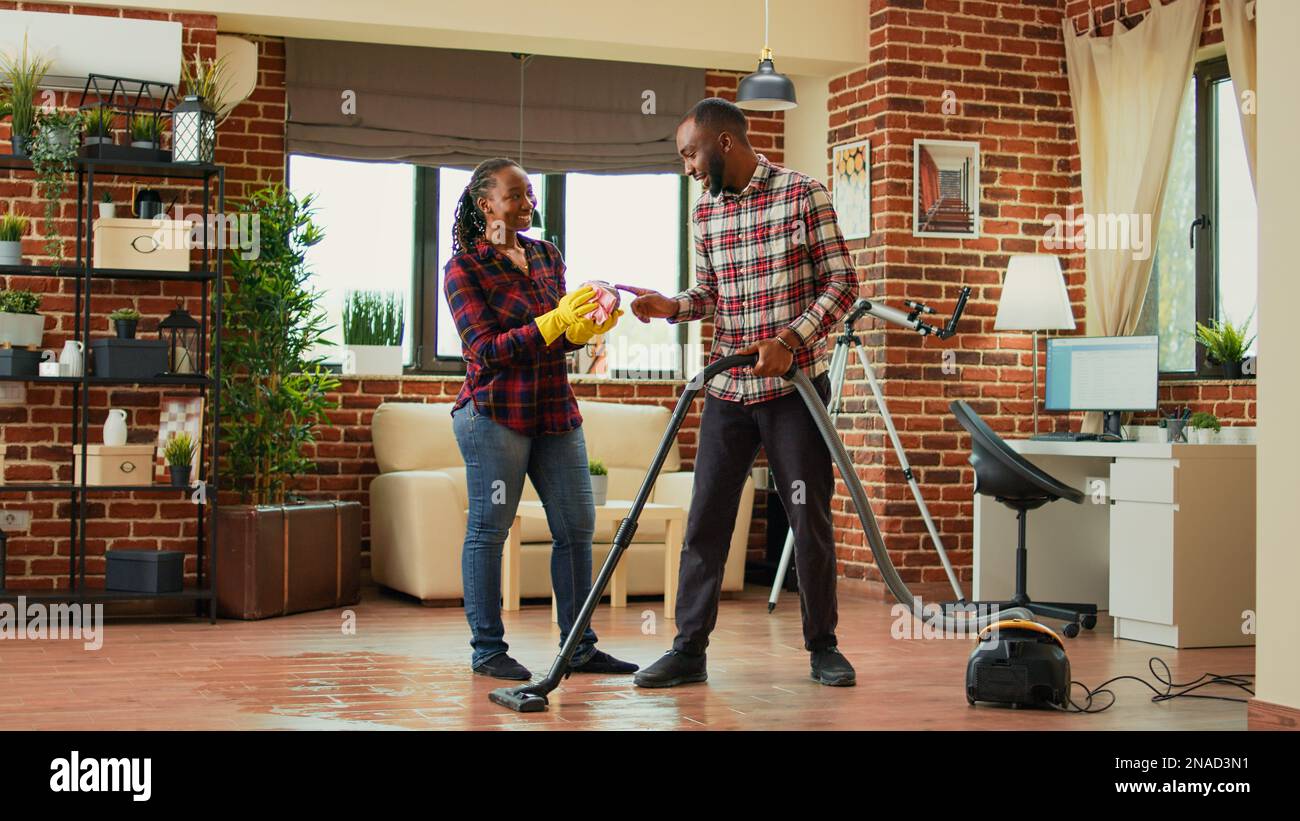 African american couple doing housework and chores, cleaning living