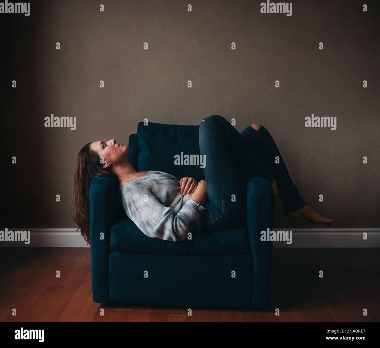 Resting In Chair Attractive woman resting in a comfortable chair in an empty room Stock ...