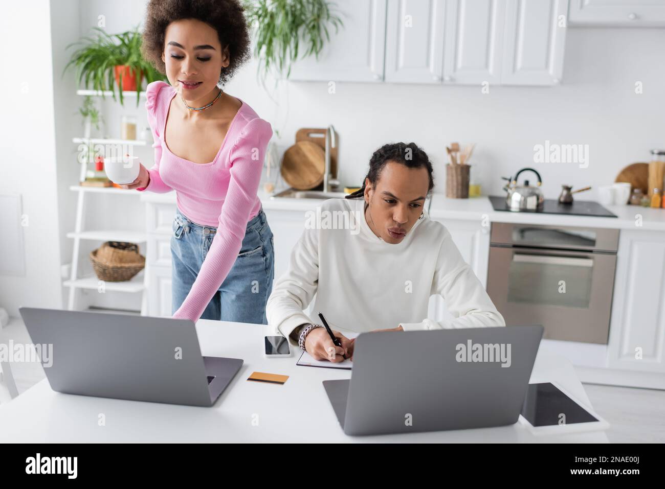 African american freelancers using laptops while working in kitchen Stock Photo