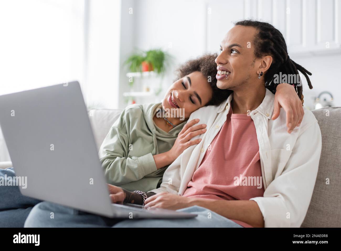 African american woman hugging boyfriend near laptop at home Stock ...