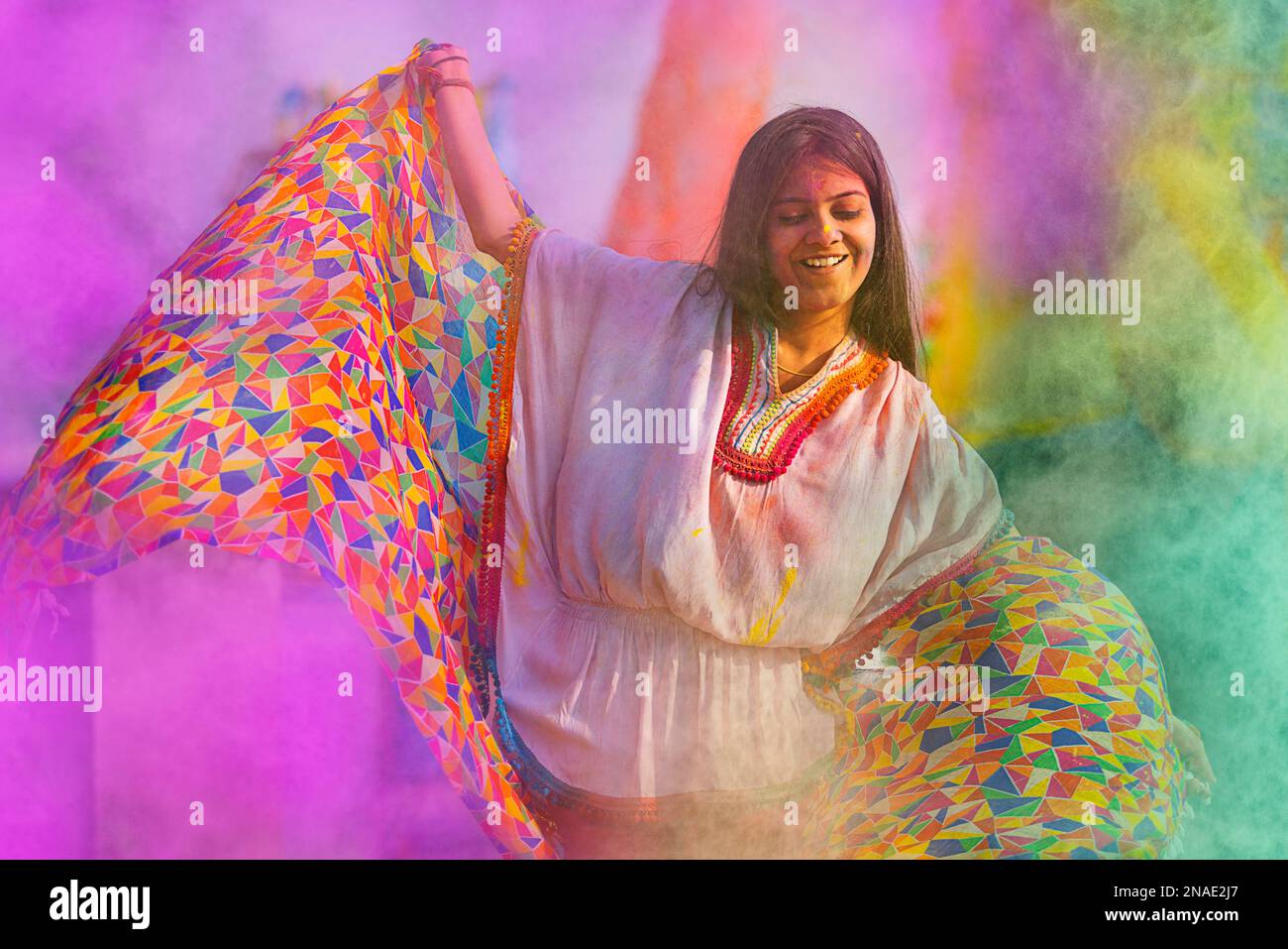 woman playing holi and dancing with gulal on her face Stock Photo