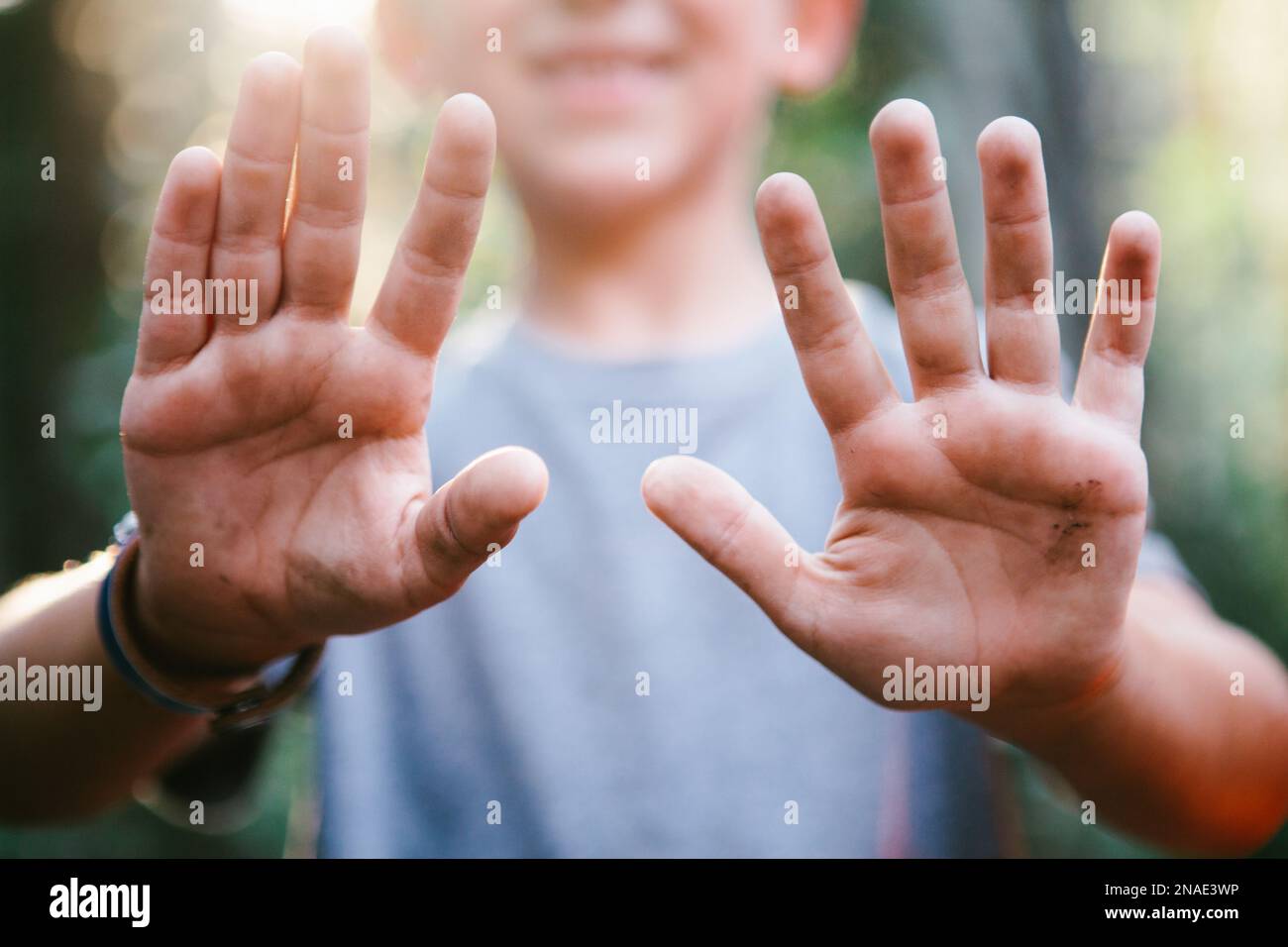 Kid with dirty hands play outside in forest out in nature adventure Stock Photo