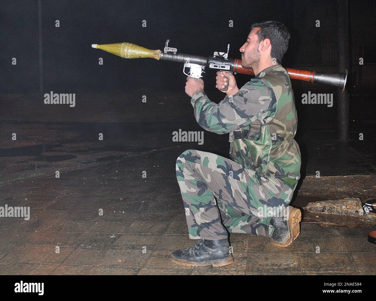 A Syrian army defector, takes his position as he holds his launcher of ...